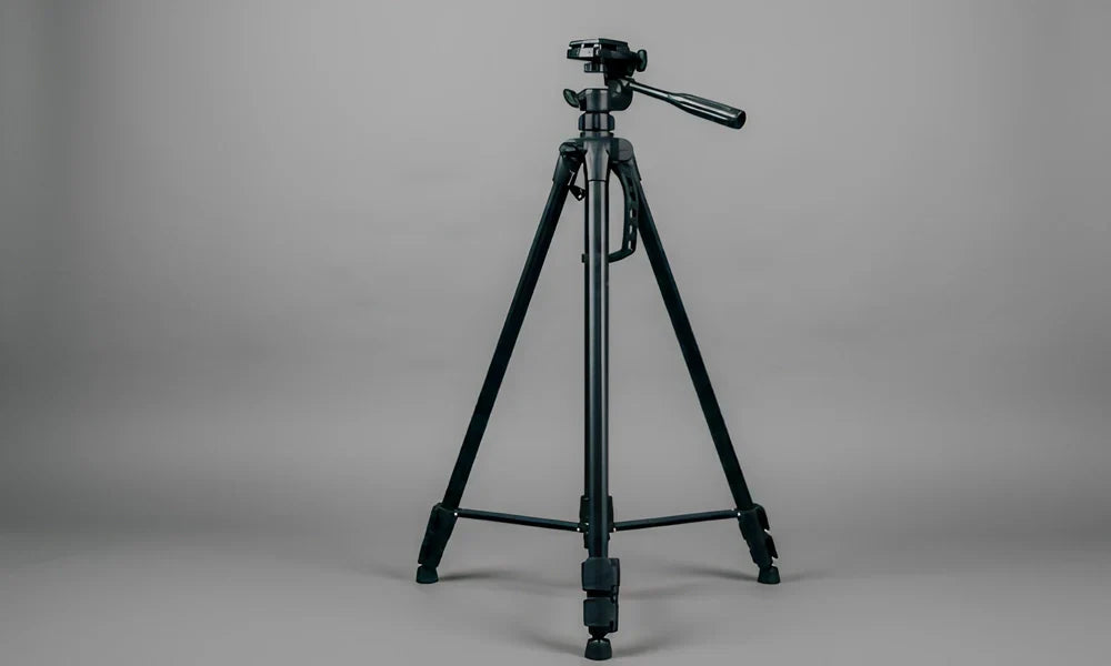 Photographe en studio utilisant un trépied pour stabiliser son appareil photo