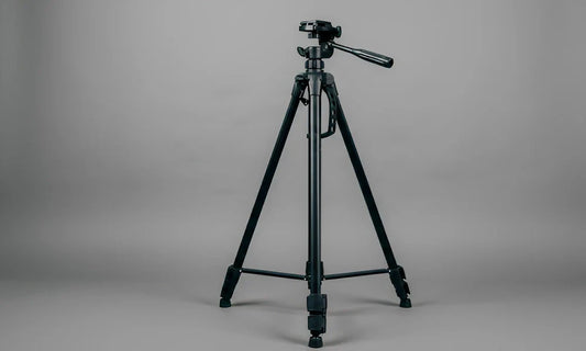 Photographe en studio utilisant un trépied pour stabiliser son appareil photo