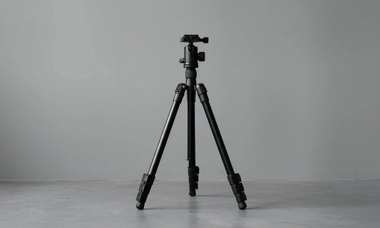 Photographe utilisant un trépied vidéo pour filmer une scène en extérieur