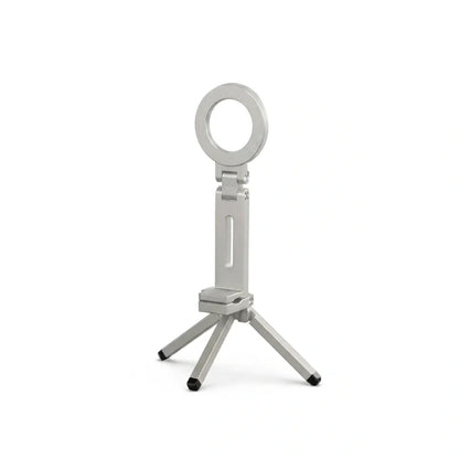 Mini trépied téléphone argenté avec anneau magnétique circulaire en haut et quatre petits pieds noirs, sur fond blanc