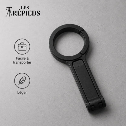 Anneau magnétique noir plié à plat avec logo Les Trépieds sur fond gris béton, compact et léger
