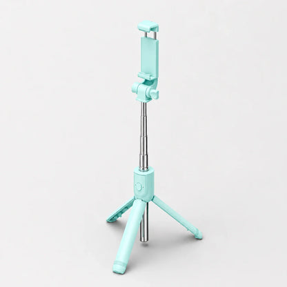 Mini trépied perche selfie turquoise et argent extensible en vue trois quarts, support téléphone turquoise, trois pieds déployés, sur fond gris clair