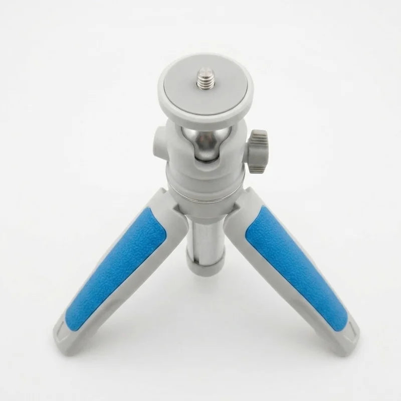 Gros plan mini trépied blanc et bleu en position basse, rotule argentée et pieds à motifs bleus vus de face sur fond blanc