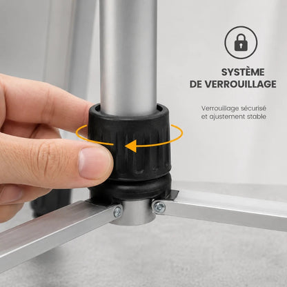 Main serrant le bouton de verrouillage du trepied laser gris
