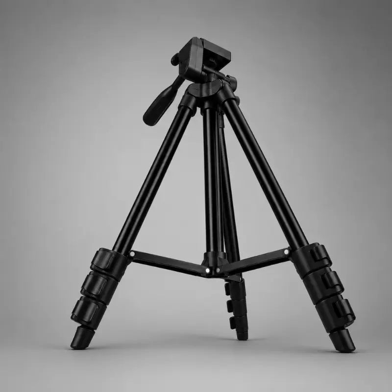 Trépied téléphone noir en position basse sur fond gris, tête 3 voies noire avec levier, jambes très écartées, vue trois quarts